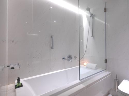 a bathroom with a shower and a tub and a sink at SAZ City Life Boutique Hotel in Ioannina