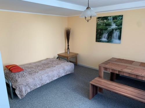Un dormitorio con una cama y una mesa. en Ferienwohnung Limes, en Aalen