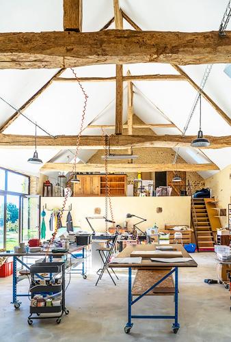 a room with tables and chairs in a building at Chambre d'Hôtes chez Artiste Verrier, La Perrière - Perche in La Perrière