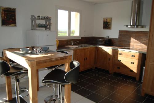 - une cuisine avec une table en bois et des tabourets de bar dans l'établissement Gite Labradors De Bailly - Giverny, à Saint-Pierre-la-Garenne