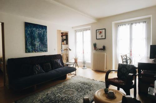un salon avec un canapé et une chaise dans l'établissement Bright And Charming F2 Near Republique, à Paris