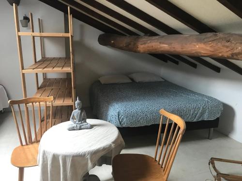 1 dormitorio con 1 cama, mesa y sillas en Gîte à la ferme La Bedigue, en Lambert