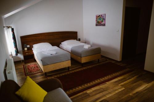 a bedroom with two beds and a couch at Hotel AB in Tychy