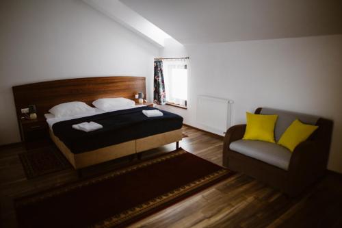 a bedroom with a bed and a chair at Hotel AB in Tychy