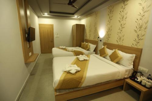 Dos camas en una habitación de hotel con toallas. en VIPs Hotel Olive en Siliguri