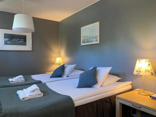 a bedroom with two beds with blue walls at Boutique hotel Sawohouse in Kuopio