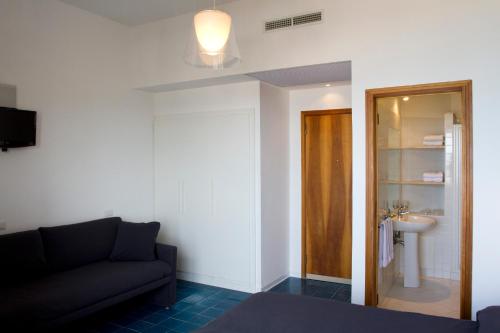 a living room with a couch and a sink at Hotel La Playa in Acciaroli