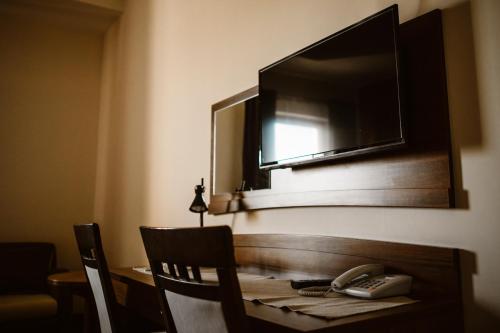 a table with a telephone and a mirror on a wall at Hotel AB in Tychy