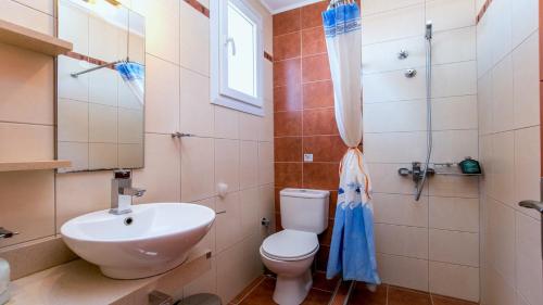 a bathroom with a toilet and a sink at Amversa's House in Potos
