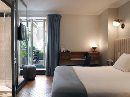 a hotel room with a bed and a desk at Hotel Bachaumont in Paris
