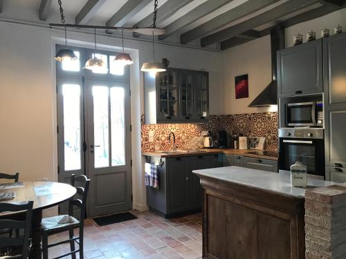 une cuisine avec un comptoir et une table à l'intérieur dans l'établissement La Barillerie, à La Flèche