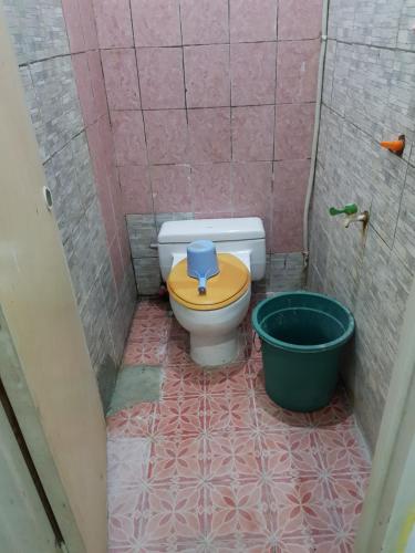 a bathroom with a toilet with a bucket in it at Hotel Alifah 2 in Tangerang