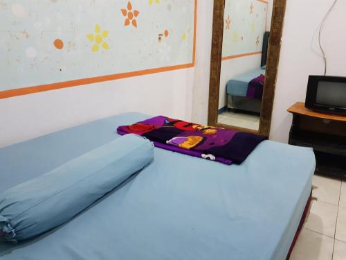 un letto in una camera con specchio di Hotel Alifah 2 a Tangerang