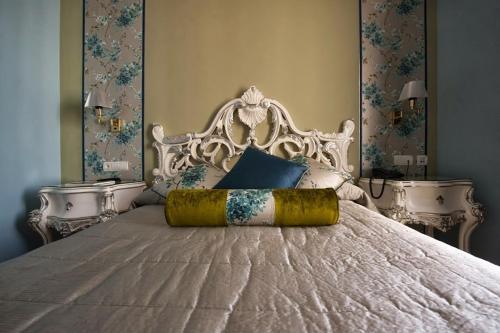 a bedroom with a white bed with a white headboard at Adriano Boutique Sevilla in Seville