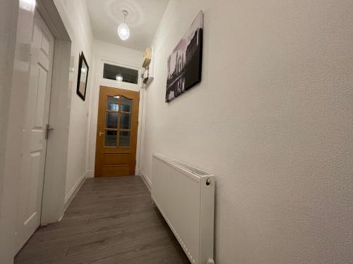 a hallway with a stairway with a door and a hallwayngth at HLA Holytown in Mossend