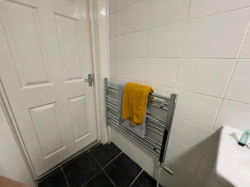a bathroom with a shower with a yellow towel at HLA Holytown in Mossend