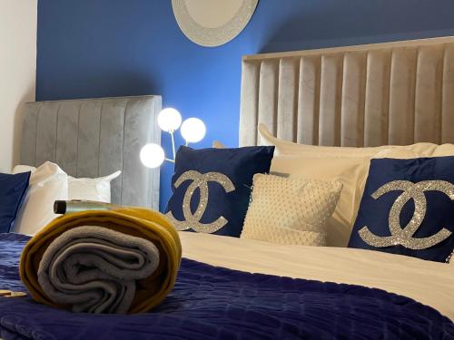 a bedroom with a bed with blue and white pillows at HLA Holytown in Mossend