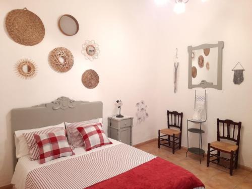 1 dormitorio con 1 cama y algunas sillas en Apartamentos Rurales Fuente de Marzo, en Anna