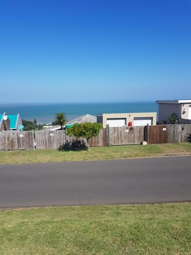 a house on the side of a road next to a fence at Ocean Rush in Zinkwazi Beach