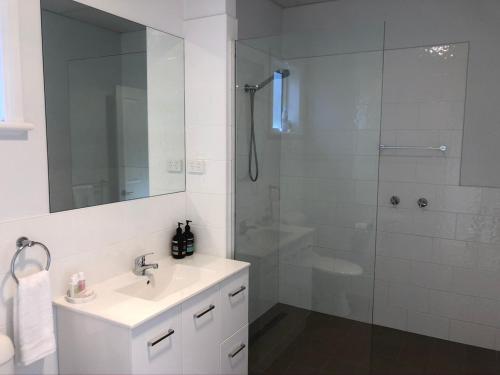 a white bathroom with a sink and a shower at Peppertree Hill in Mudgee