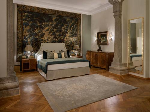 a bedroom with a bed and a large painting on the wall at Hotel Schloss Mönchstein in Salzburg