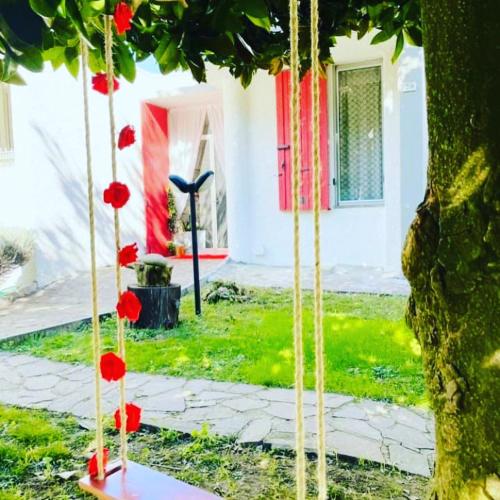 a tree with red flowers on it in front of a house at Villa Tanya in Trebbiantico