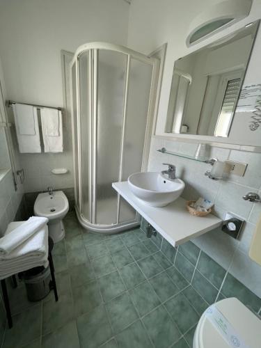 a bathroom with a shower and a sink and a toilet at Villa Liliana in Cervia