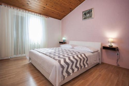 a bedroom with a bed and a large window at Apartments Vukicevic in Šibenik