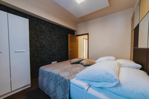 a bedroom with a bed with blue and white sheets at Hotel Brcko Gas Prijedor in Prijedor