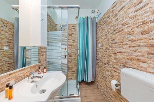 La salle de bains est pourvue d'un lavabo blanc et d'un miroir. dans l'établissement Apartment Castello, à Rovinj