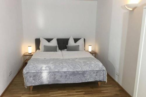 um quarto branco com uma cama grande e 2 candeeiros em Gästewohnung Helena em Völkermarkt