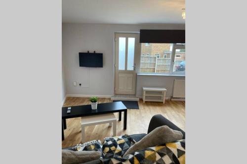 a living room with a couch and a tv at Idyllic Self Contained Annex Flat in Eaton in Cringleford