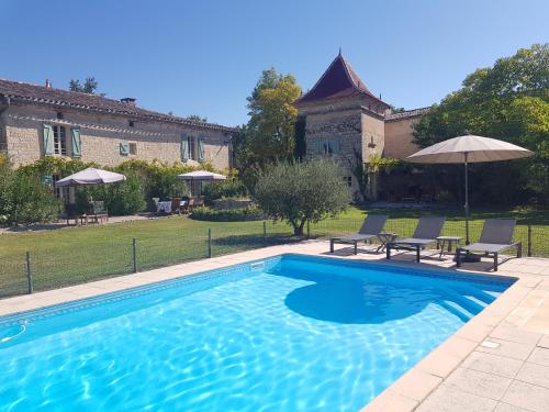 - une piscine en face d'une maison avec 2 chaises dans l'établissement Villa Mas, à Cestayrols
