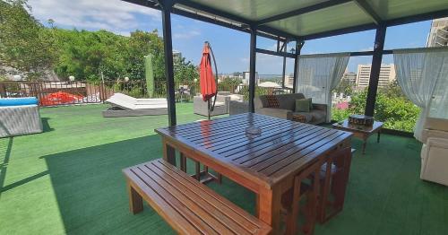 a patio with a wooden table and an umbrella at GuestHouse 1109 in Maputo