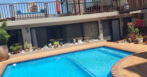 a large blue swimming pool in front of a building at GuestHouse 1109 in Maputo