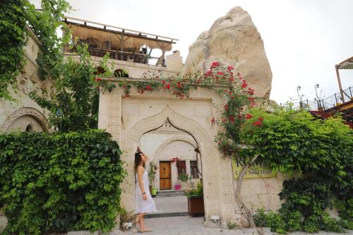 a woman standing in front of a building at Roma Cave Suite in Goreme