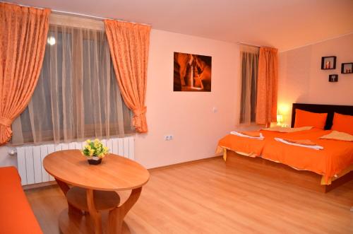 a bedroom with two beds and a table in it at Стаи за Гости Тони и Крис in Devin
