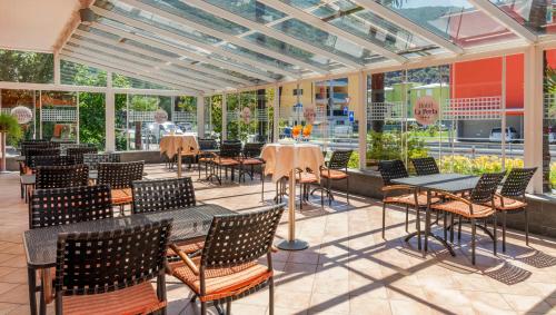 an empty restaurant with tables and chairs and windows at Hotel La Perla in Sant' Antonino (S. Antonino)