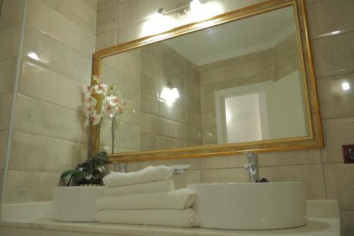 a bathroom with a sink and a mirror and towels at Apartamentos Pirámides in Playa de las Americas