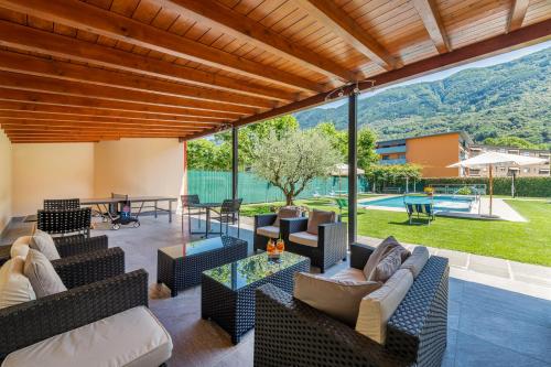 un patio al aire libre con muebles y vistas a la piscina en Hotel La Perla, en SantʼAntonino