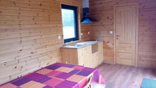 a room with a kitchen and a sink in a wooden room at Villa Dikaria in Montacher