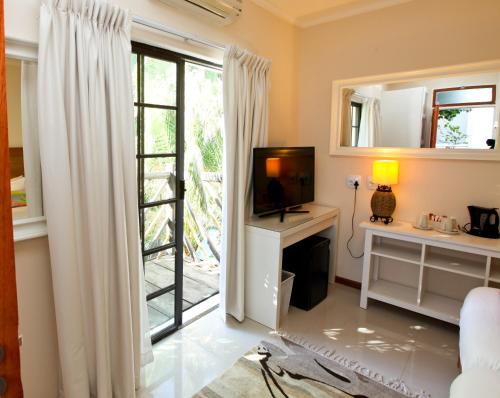 a living room with a tv and a window at Roof of Africa Hotel in Windhoek