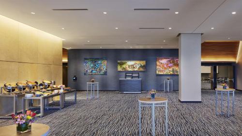 a lobby with tables and paintings on the walls at InterContinental Minneapolis - St. Paul Airport by IHG in Minneapolis