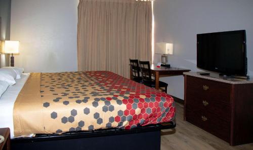 a hotel room with a bed and a flat screen tv at Econo Lodge Ardmore in Ardmore