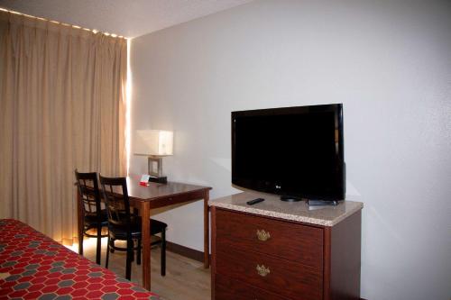 a hotel room with a flat screen tv on a dresser at Econo Lodge Ardmore in Ardmore