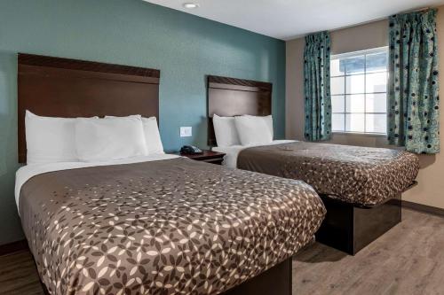 a hotel room with two beds and a window at Rodeway Inn in Caldwell