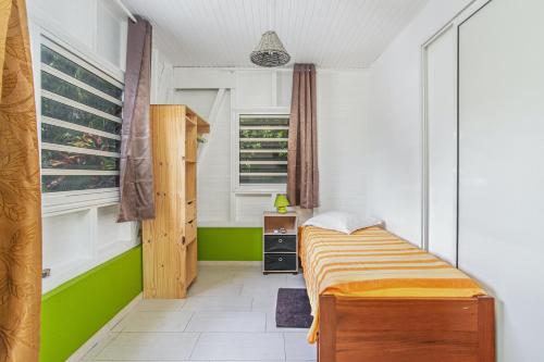a small bedroom with a bed and a window at Bungalow charmant à Rivière-Salée avec terrasse privée in Rivière-Salée