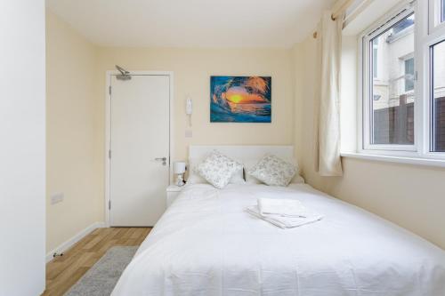 a bedroom with a large white bed and a window at Blackberry - Stylish Self-Contained Flats in Soton City Centre in Southampton