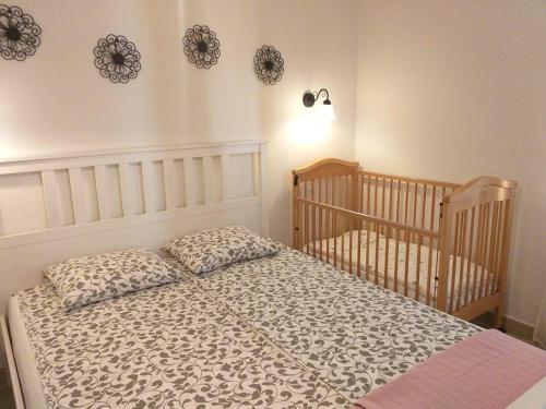 a bedroom with two cribs and a bed with pillows at APARTMANI Mirona - Tučepi in Tučepi