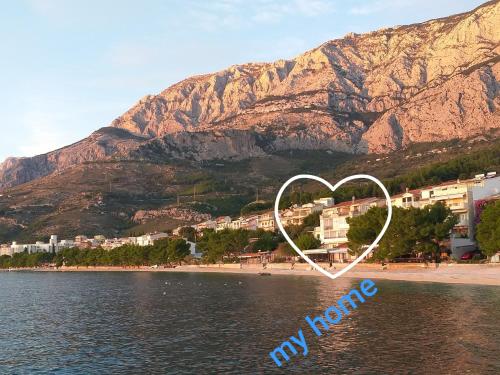 a heart painted on a beach with a mountain in the background at APARTMANI Mirona - Tučepi in Tučepi